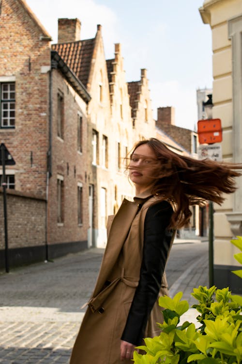 Stylish woman on old street in windy weather