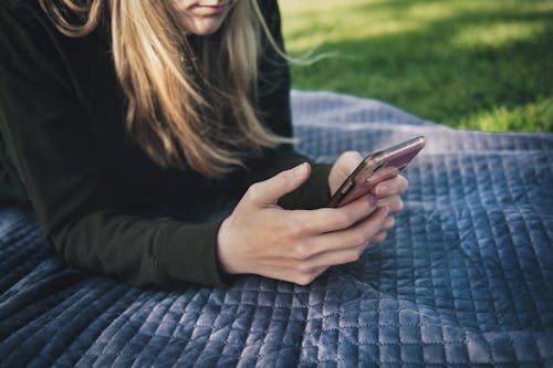 Ücretsiz akıllı telefon, battaniye, çim içeren Ücretsiz stok fotoğraf Stok Fotoğraflar