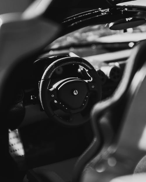 From above black and white of contemporary style automobile interior with steering wheel with buttons