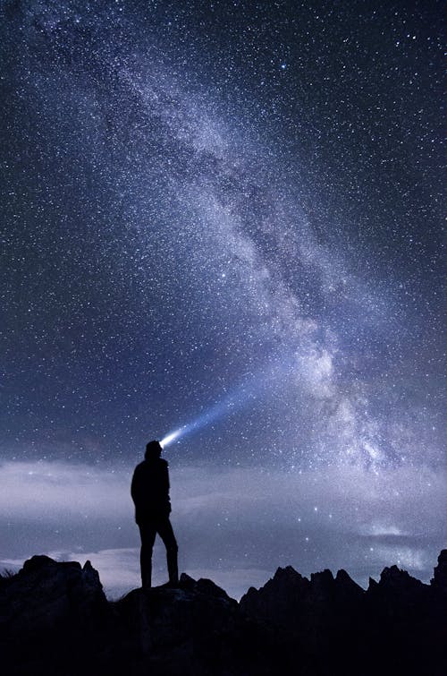 Silhouette of Man Standing on Mountain during Night