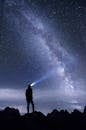 Silhouette of Man Standing on Mountain during Night