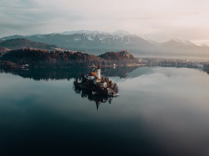 A tranquil aerial view of Lake Bled and its island in Slovenia during a misty day.