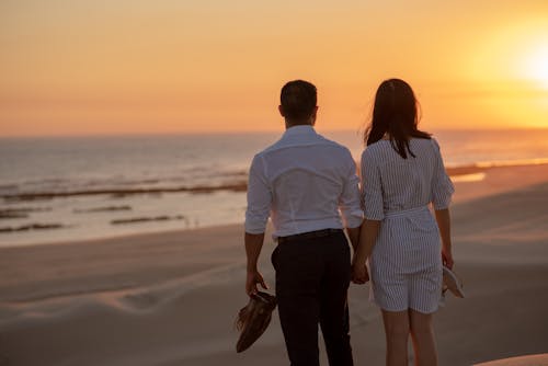 Couple Standing on Beach during Sunset