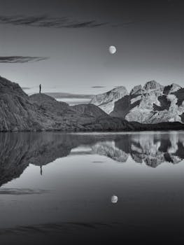 Tranquil moonlit landscape at Lago Nero, Trentino-Alto Adige, with mountain reflections.