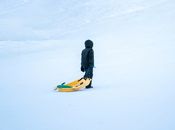 Man in Black Jacket and Black Pants Standing on Yellow and Blue Kayak on Snow Covered