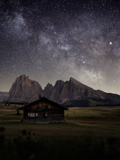 Free Old building on lawn behind rocks under starry sky Stock Photo