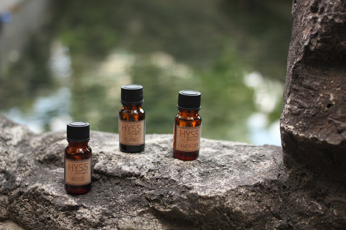 Three Brown Glass Bottles on Gray Rock