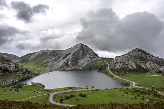 Scenic view of Asturias mountains and lake under a dramatic cloudy sky.