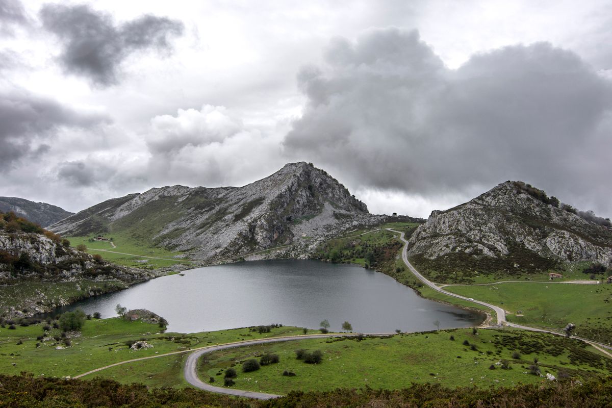 Lac și munte stâncos sub cer înnorat, în nordul Spaniei