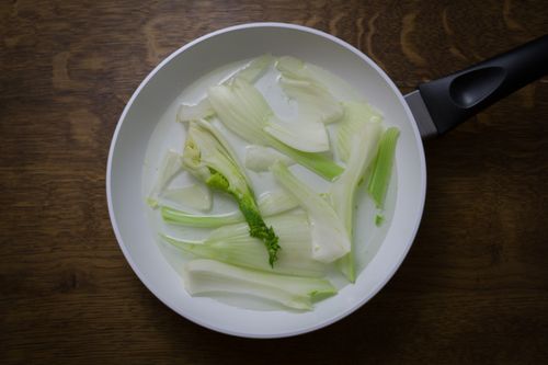 Free Overhead view of fresh fennel slices in a white frying pan. Perfect for healthy cooking concepts. Stock Photo