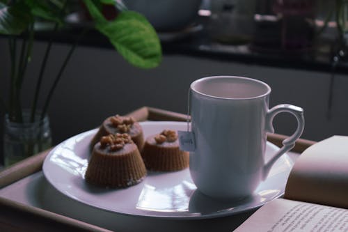 Cup of tea served with chocolate cupcakes