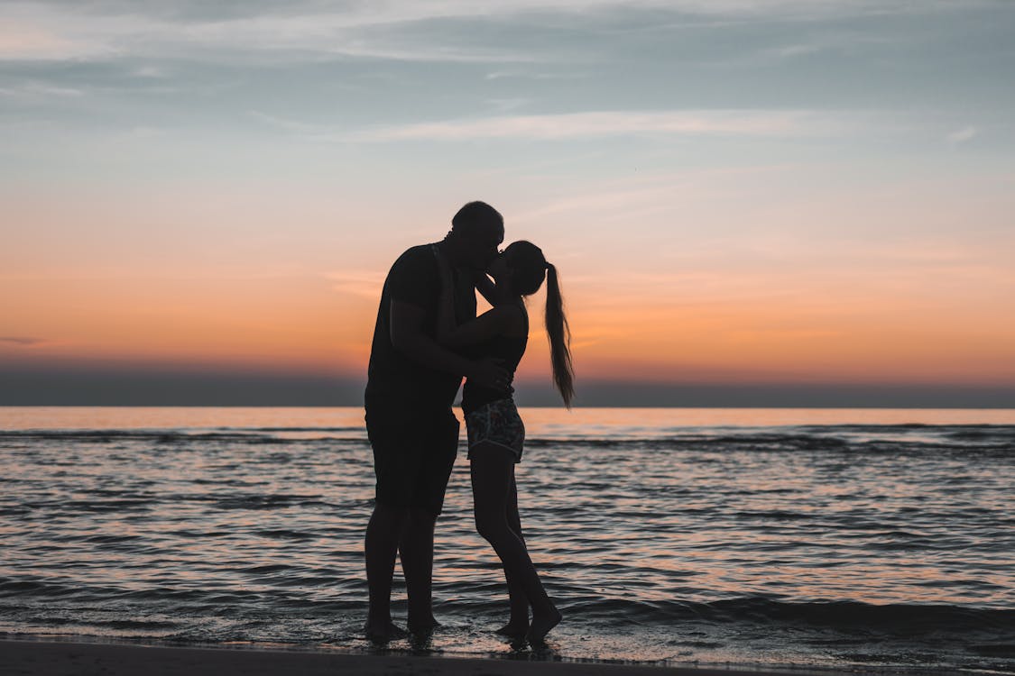 Free Man and Woman Kissing on Beach during Sunset Stock Photo