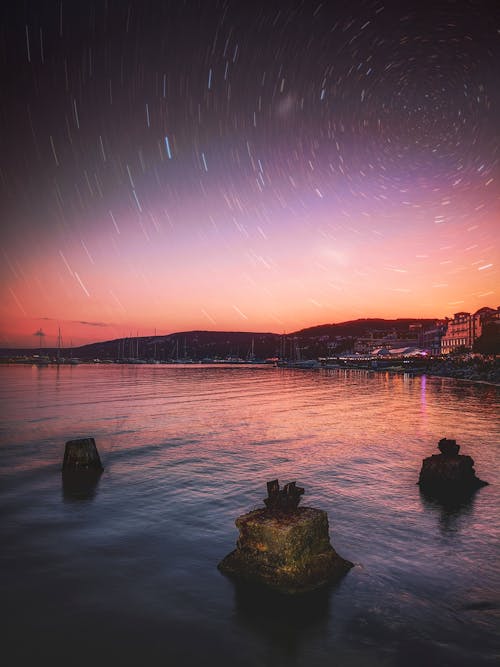 Free Amazing scenery of starry night sky above coastal town Stock Photo