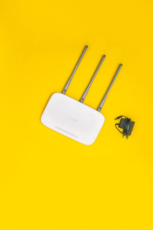 A white broadband router with ethernet cables connected, representing the internet infrastructure required to stream IPTVUK channels at high quality to UK homes.