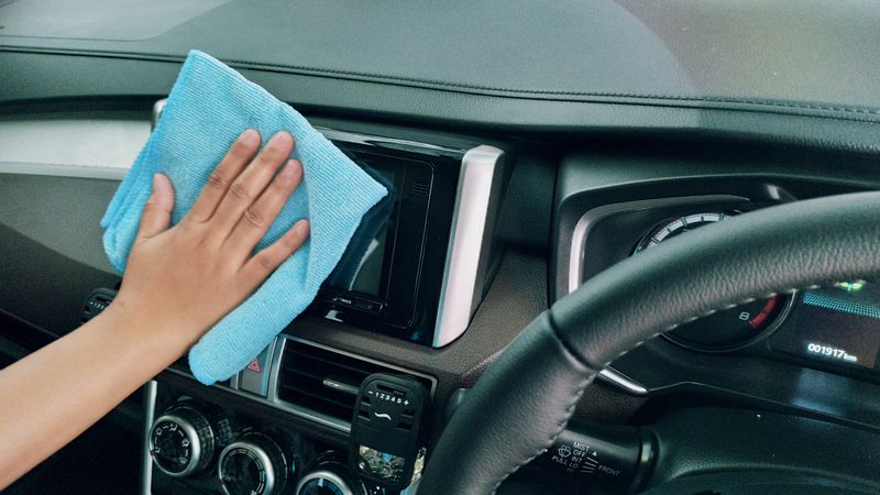 Seseorang mengelap panel mobil