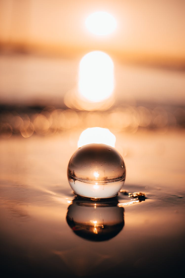 Glass Ball On Calm Lake Water Surface In Evening