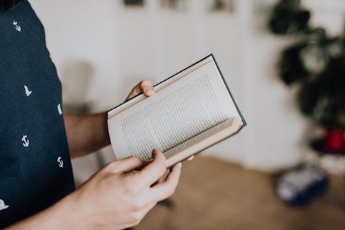 Person Holding White Book Page