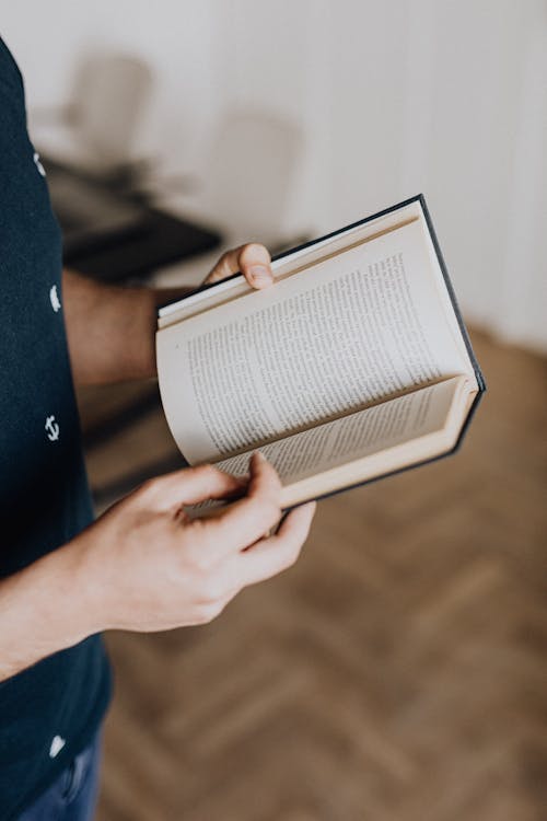 Photo of Person Holding Opened Book