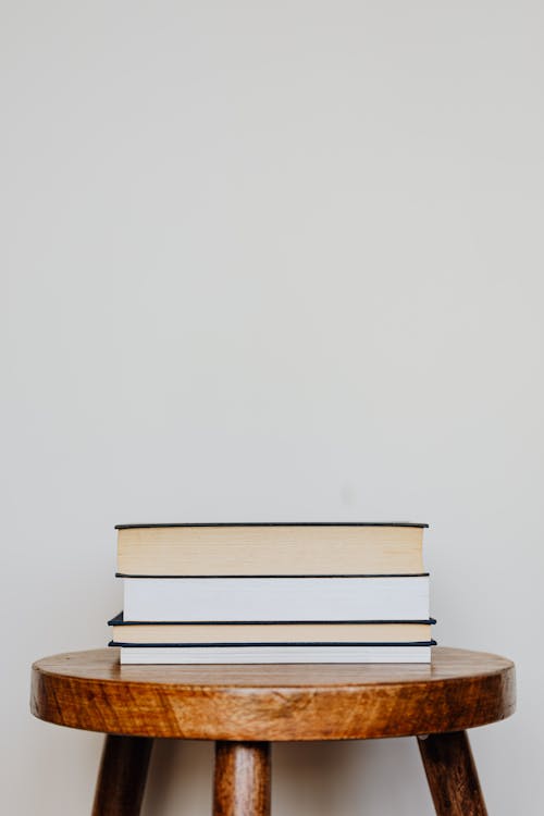 Close-Up Photo of Stack of Books on Wooden Stool