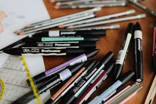 Scattered stationery of colourful drawing markers and pencils on working table of architect