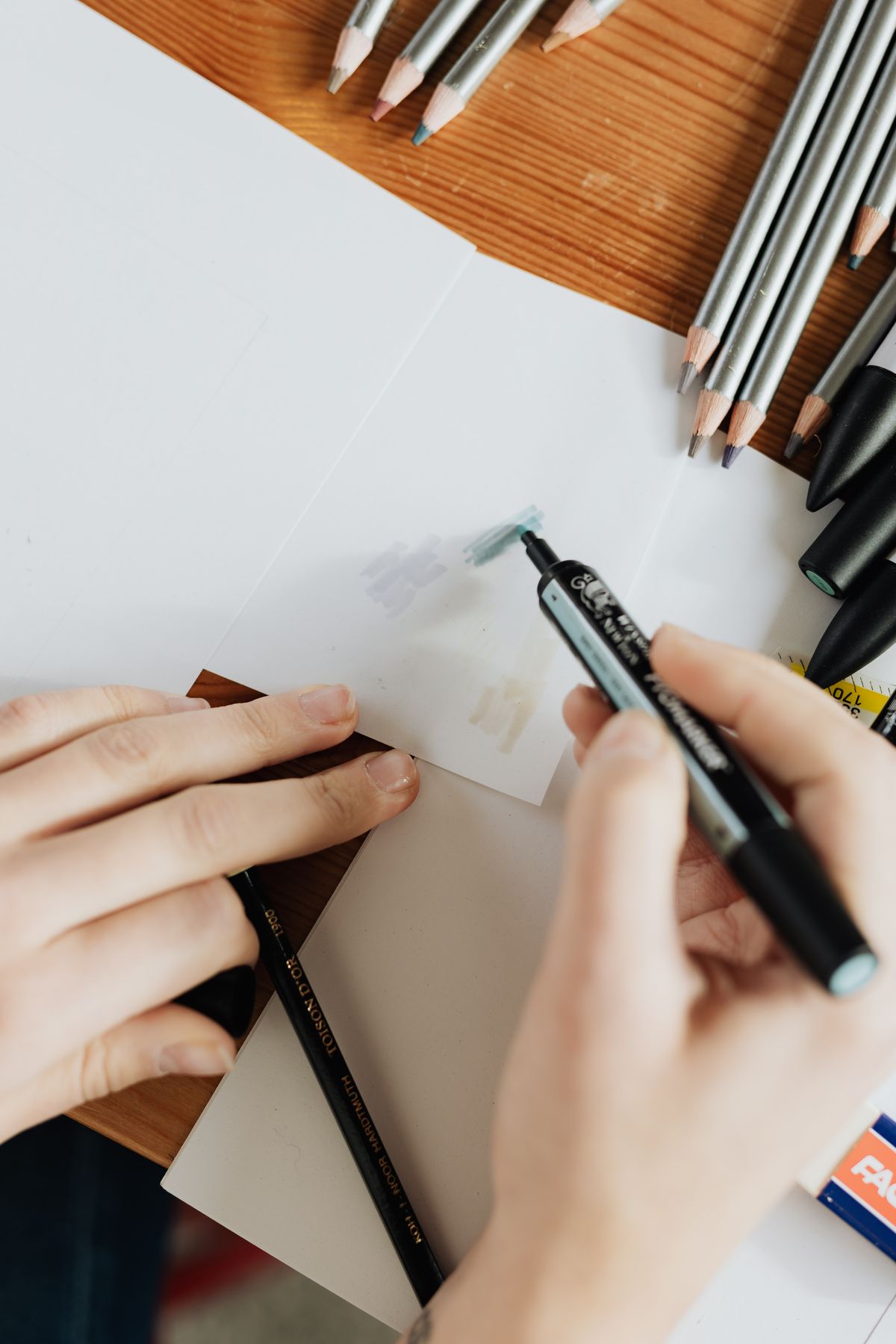 Person drawing with a marker at a desk