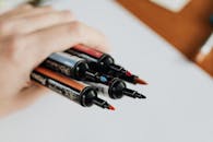 Crop unrecognizable person showing set of markers at work