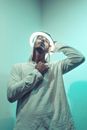 Calm ethnic man putting illuminating neon round lamp on head
