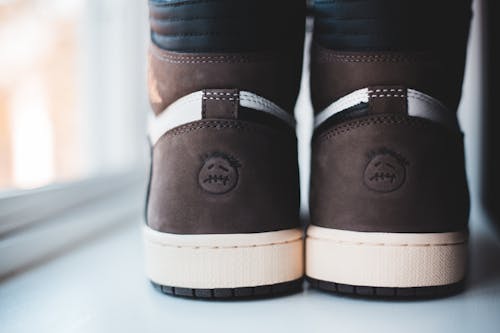 Trendy suede sneakers placed on white windowsill