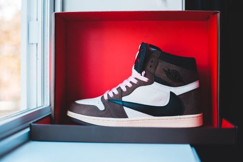Free Trendy modern brown and white warm leather sneakers placed in box on windowsill Stock Photo