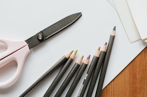 Close-Up Photo of Scissors Beside Coloring Pencils