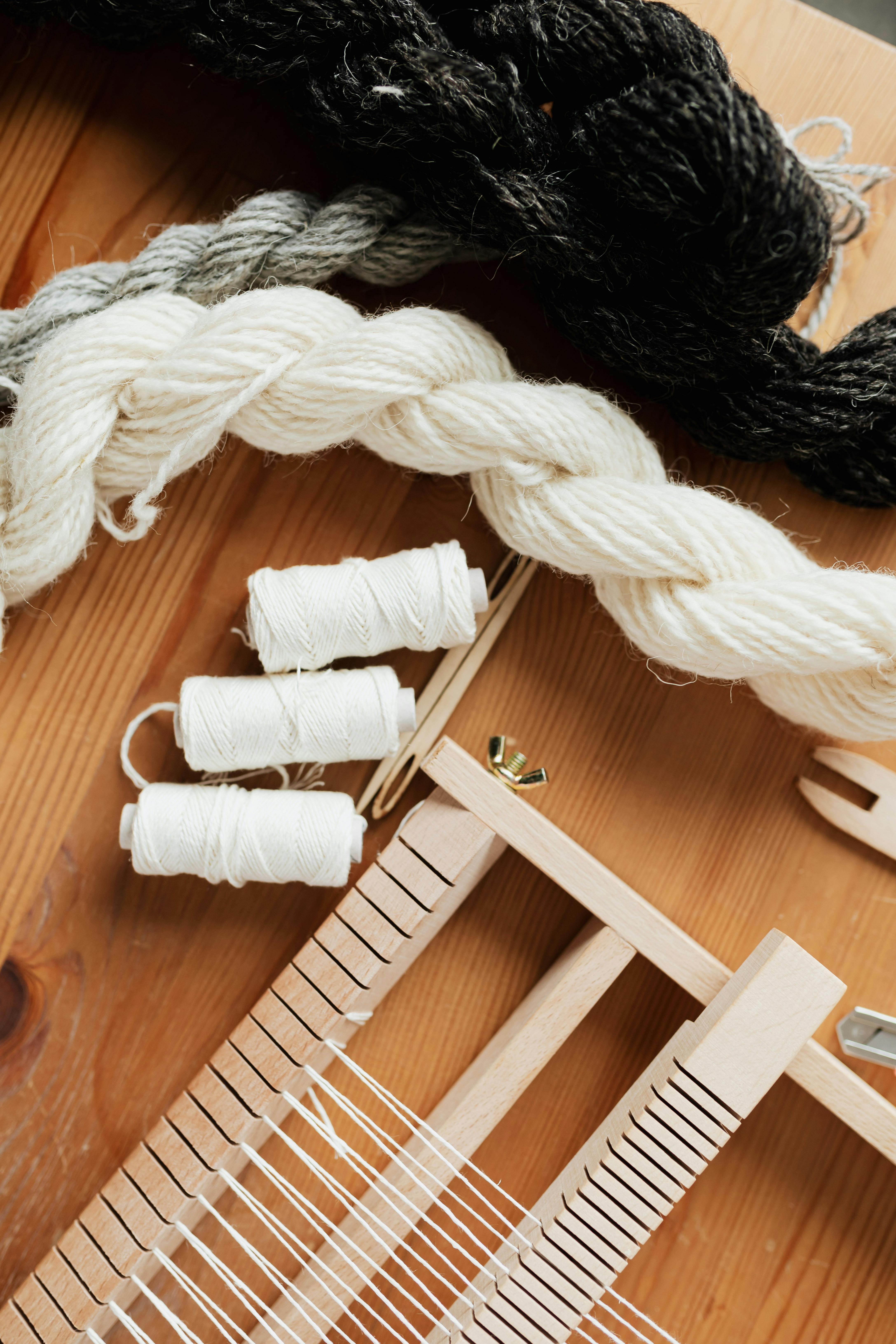 small hand wooden loom with yarn and thread