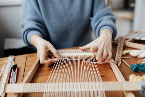 Free Person Weaving Using Hand Loom Stock Photo