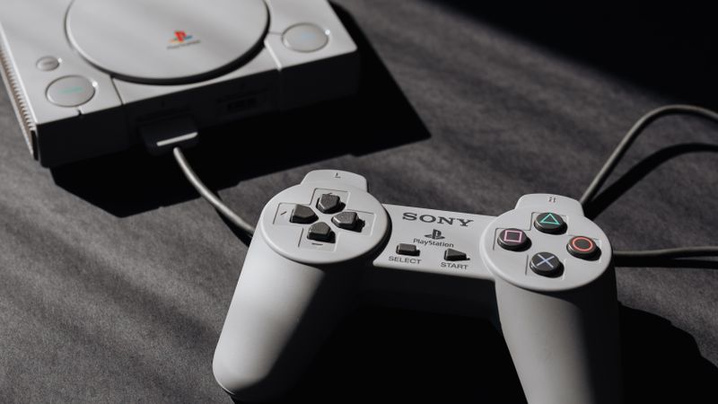 Retro Sony PlayStation console with classic controller, evoking nostalgic gaming memories.