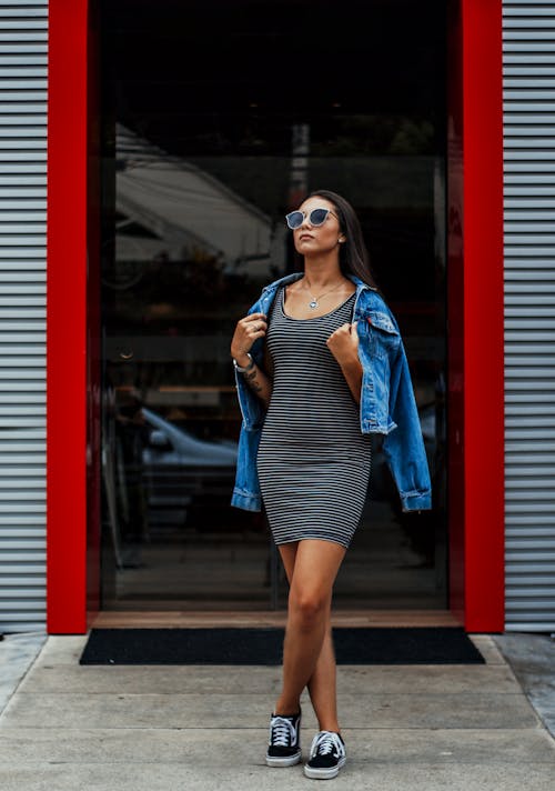 Fashionable young lady standing on street and looking away