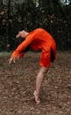 Woman in Orange Dress Standing on Ground