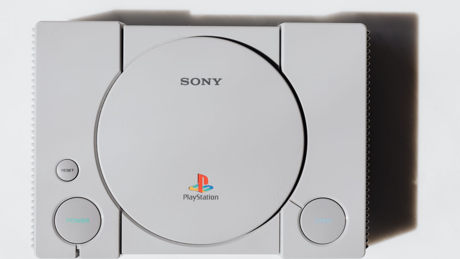 Close-up of the original Sony PlayStation console on a white background, no people in the frame, a real stock photo chosen because the first PlayStation is where console games moved to discs, and this story is about Sony ending discs for new PlayStation games