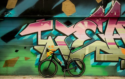 Bicycle Standing Next to a Graffiti Wall