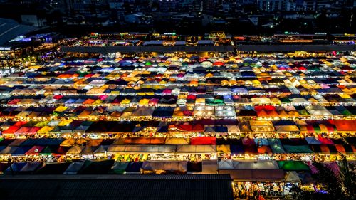 Free A colorful aerial shot of an illuminated night market in Bangkok, Thailand, showcasing diverse and vibrant stalls. Stock Photo