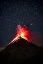 Volcano Erupting at Night Under Starry Sky