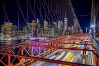 从布鲁克林桥俯瞰纽约市，夜色中的天际线充满活力，城市灯光与交通尽收眼底