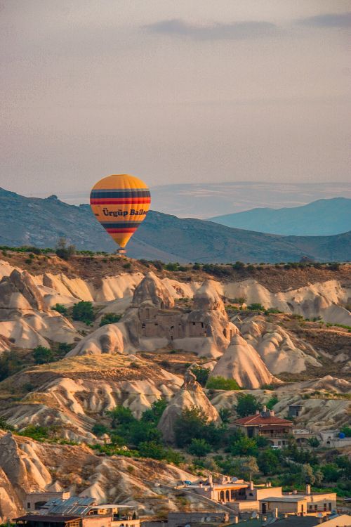 Free A vibrant hot air balloon floats over the surreal rock formations of Cappadocia, Turkey. Stock Photo