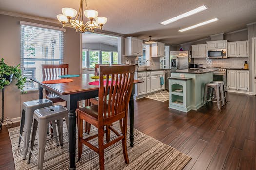 Spacious contemporary kitchen and dining area featuring a wooden table and bright interior design.