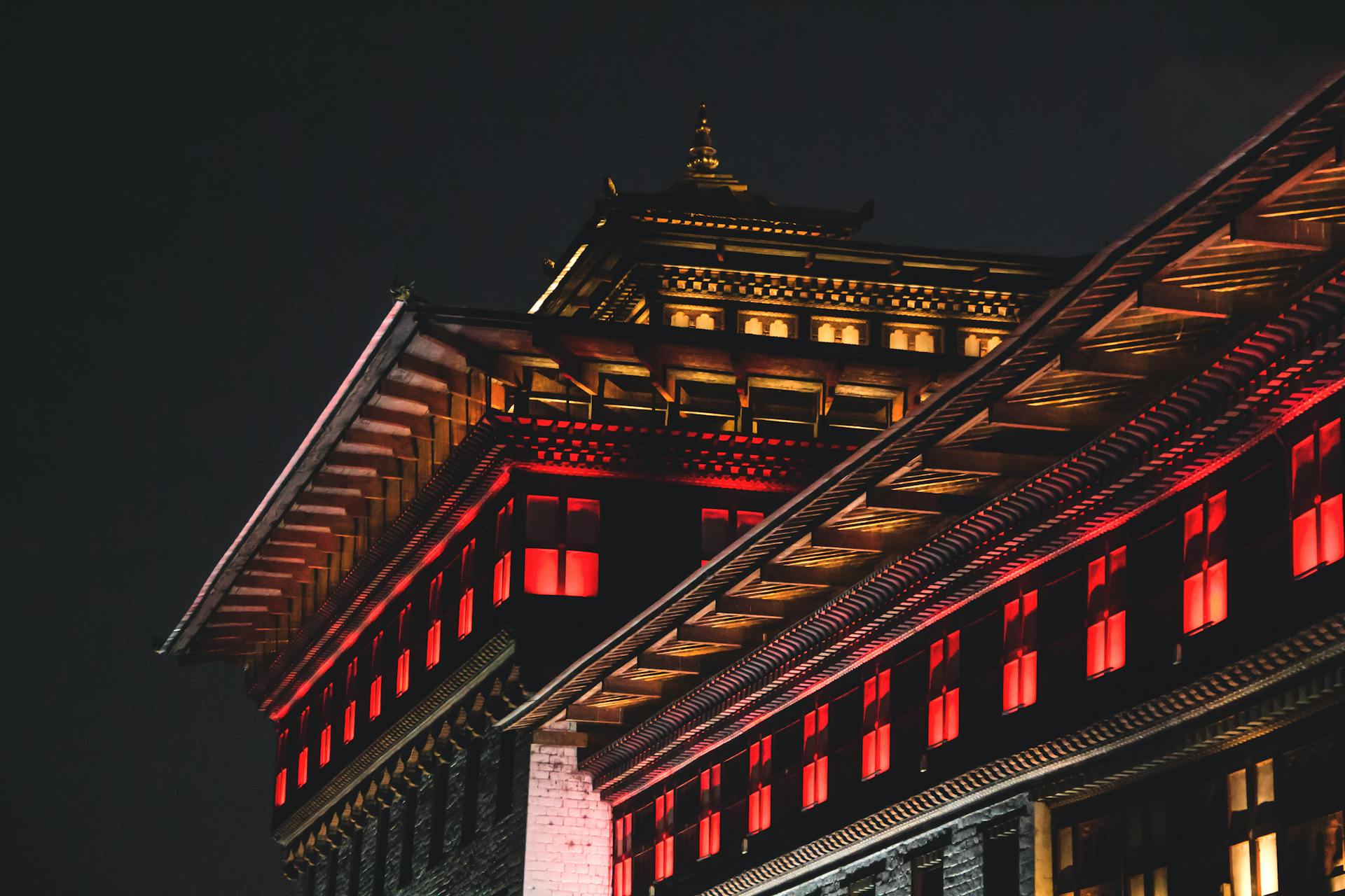 A vibrant night view of traditional Bhutanese architecture illuminated in Thimphu, Bhutan.