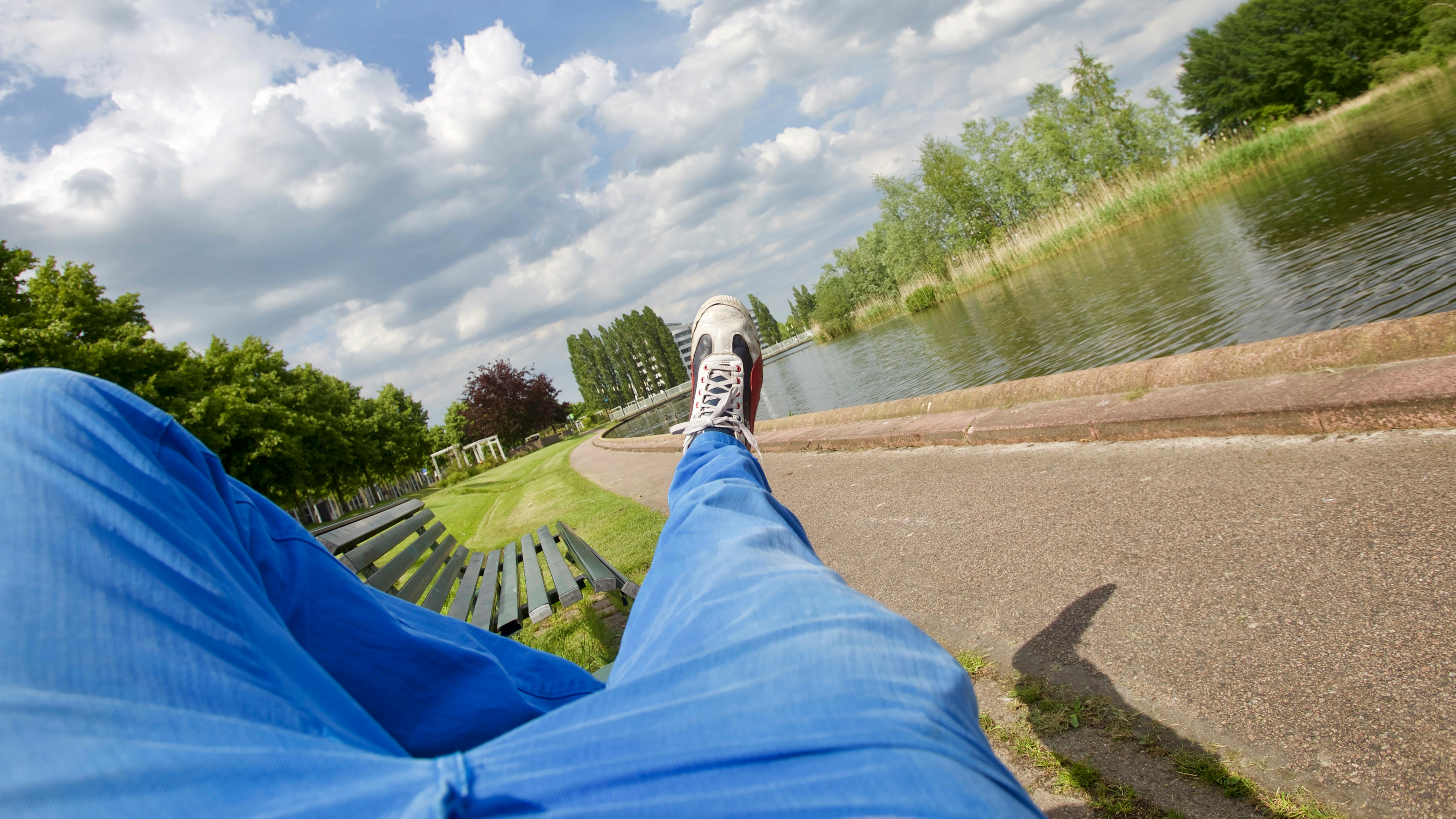 在多云的天空下，公园长凳前是一条宁静的河流