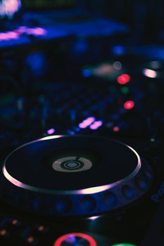 DJ mixer close-up with colorful lights, perfect for music production visuals.