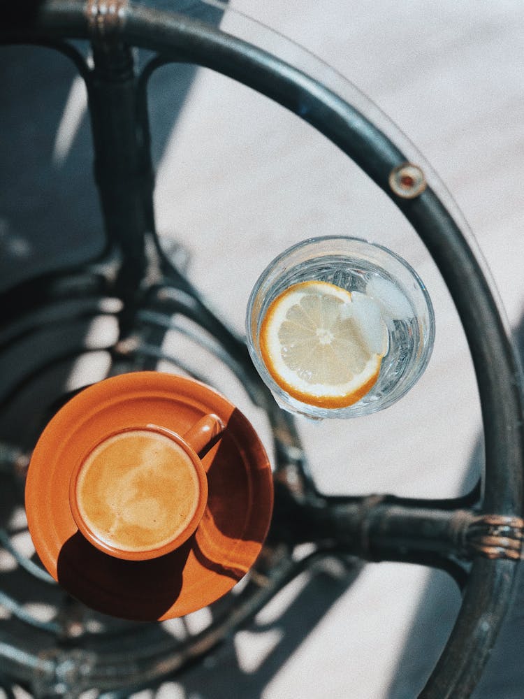 Refreshing Soda With Lemon Placed On Table With Cup Of Coffee In Cafe