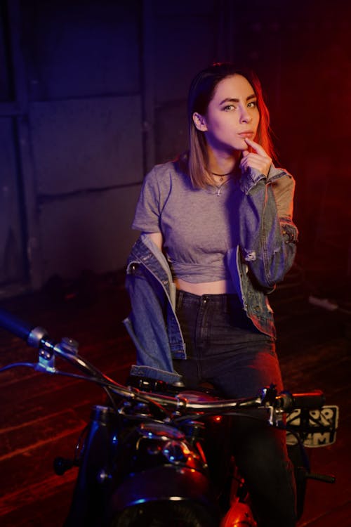 Free Confident young lady sitting on motorbike Stock Photo