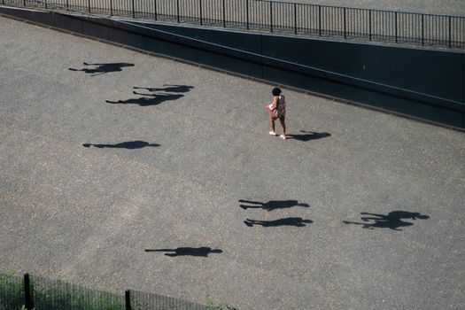 Girl in Pink Shirt and Black Pants Walking on Gray Concrete Pathway
