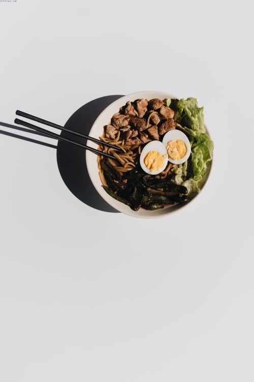 Free Flat lay of an Asian-inspired meal with noodles, eggs, and greens on a white background. Stock Photo