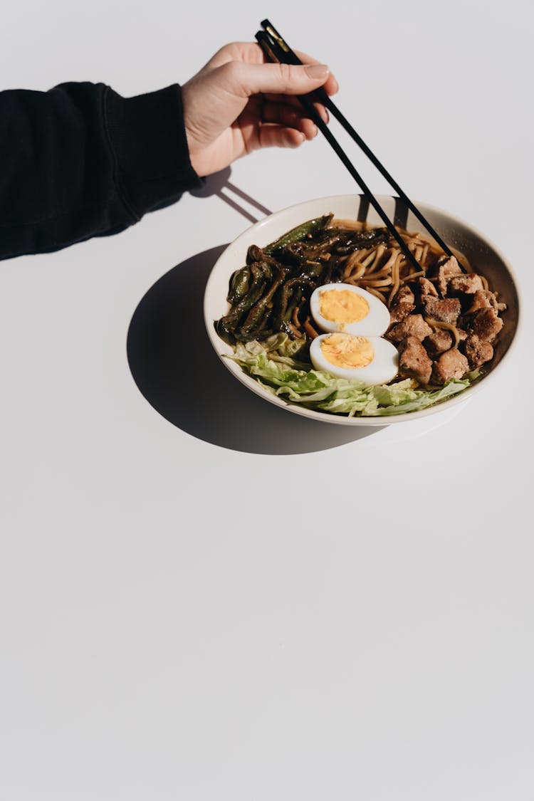 Hand Reaching With Chopsticks For Ramen